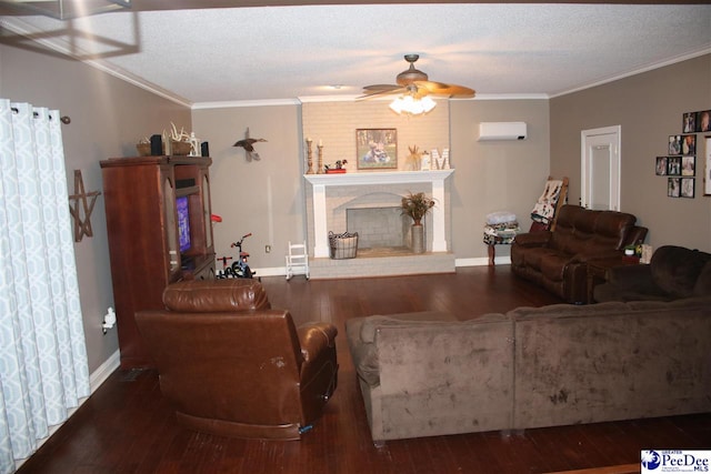 living room featuring wood finished floors, a textured ceiling, crown molding, a fireplace, and a wall mounted AC