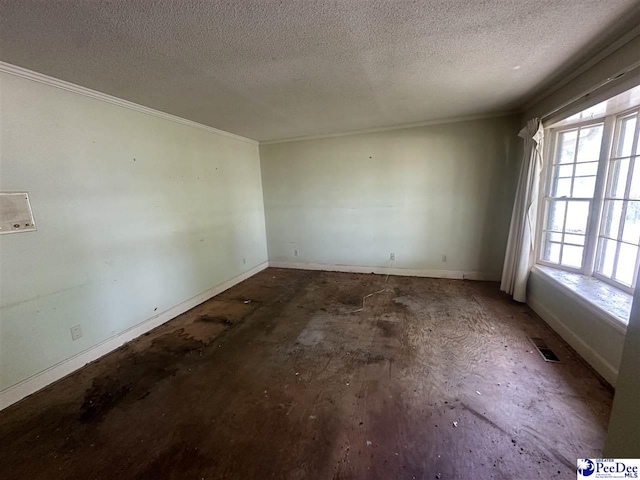 spare room featuring crown molding and a textured ceiling