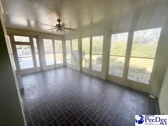 unfurnished sunroom with a ceiling fan