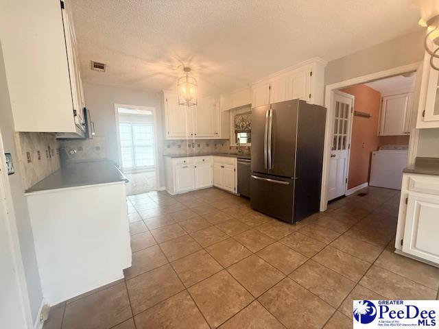 kitchen with white cabinetry, washer / dryer, visible vents, and appliances with stainless steel finishes