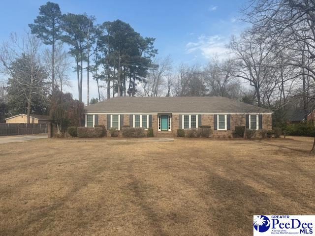 single story home with a front lawn and fence