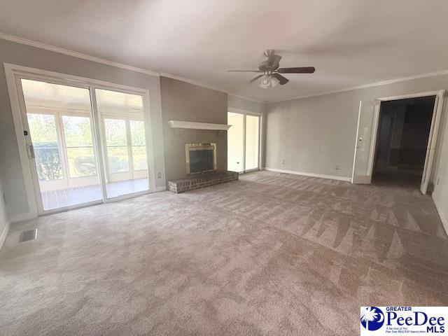 unfurnished living room with ornamental molding, visible vents, a fireplace, and carpet flooring