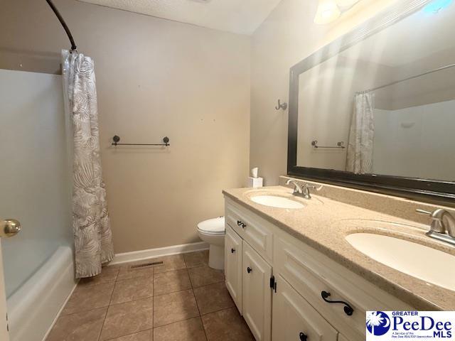 full bath with tile patterned flooring, a sink, toilet, and baseboards