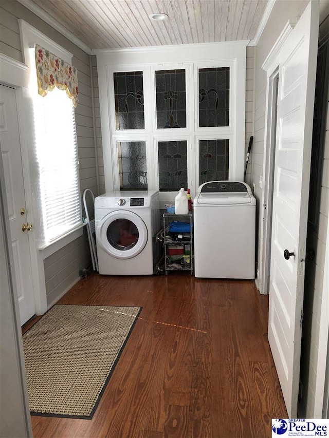 laundry room featuring dark hardwood / wood-style flooring, wood ceiling, crown molding, and washing machine and clothes dryer