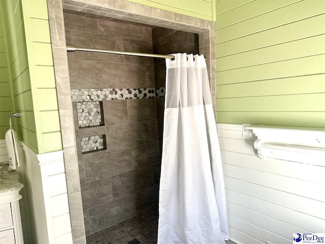 bathroom with curtained shower and wood walls