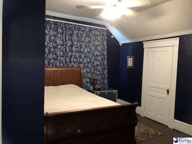 bedroom featuring dark wood-type flooring, lofted ceiling, ornamental molding, and ceiling fan