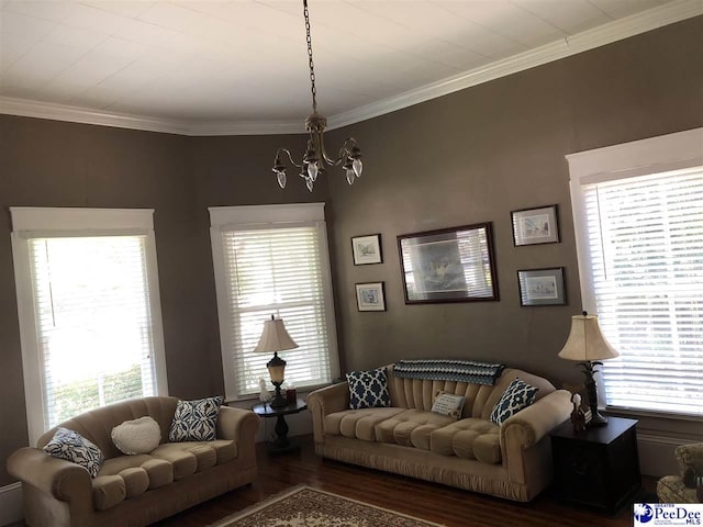 living room with hardwood / wood-style flooring, ornamental molding, and a notable chandelier