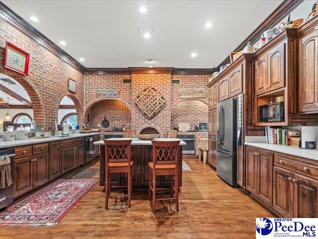 kitchen featuring appliances with stainless steel finishes, a center island, a breakfast bar area, and light wood-type flooring