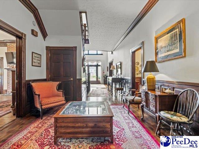 sitting room with crown molding, hardwood / wood-style flooring, and a textured ceiling