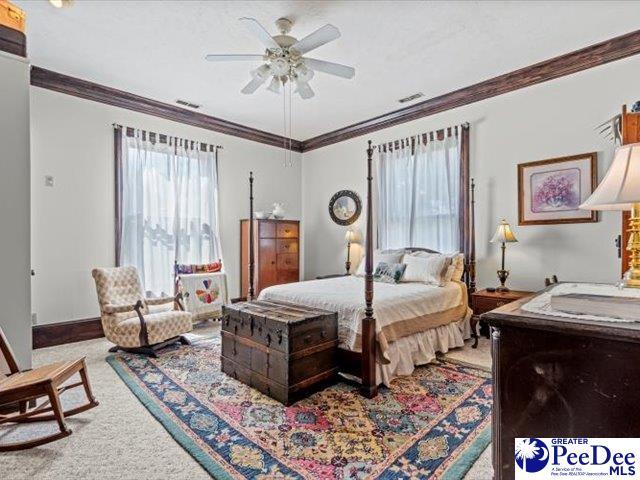 bedroom featuring crown molding, ceiling fan, and carpet floors