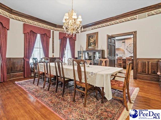 dining area with an inviting chandelier, hardwood / wood-style flooring, and crown molding