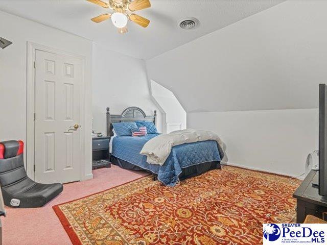 bedroom with vaulted ceiling, carpet flooring, and ceiling fan