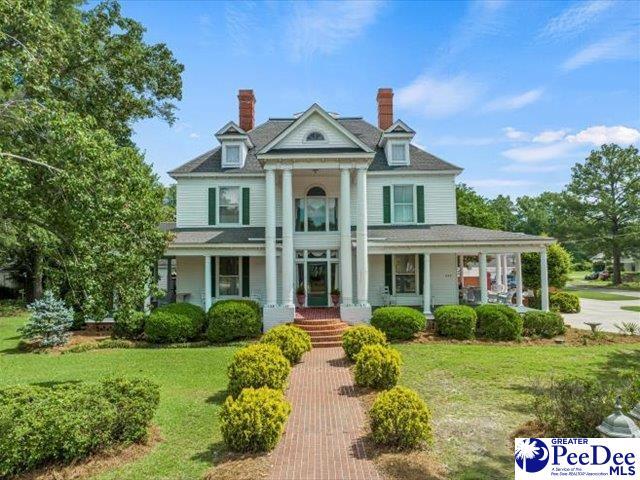 greek revival house with a porch and a front lawn