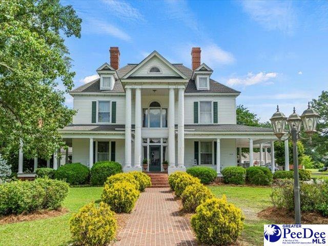 neoclassical / greek revival house featuring a front yard