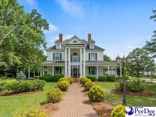 neoclassical home with a front lawn