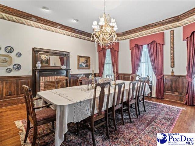 dining space featuring ornamental molding, dark wood-type flooring, and a chandelier