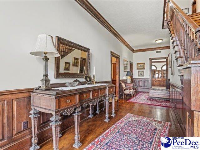 entryway with crown molding, dark hardwood / wood-style flooring, and a textured ceiling