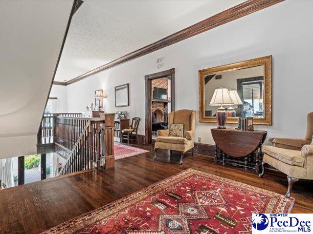 living area featuring crown molding and hardwood / wood-style floors