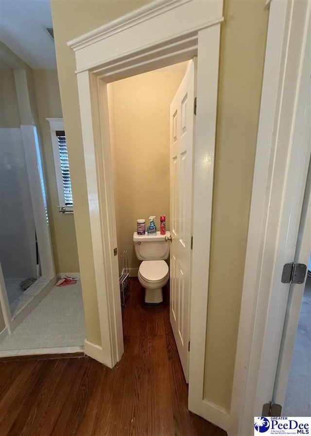 bathroom with wood finished floors, toilet, and baseboards