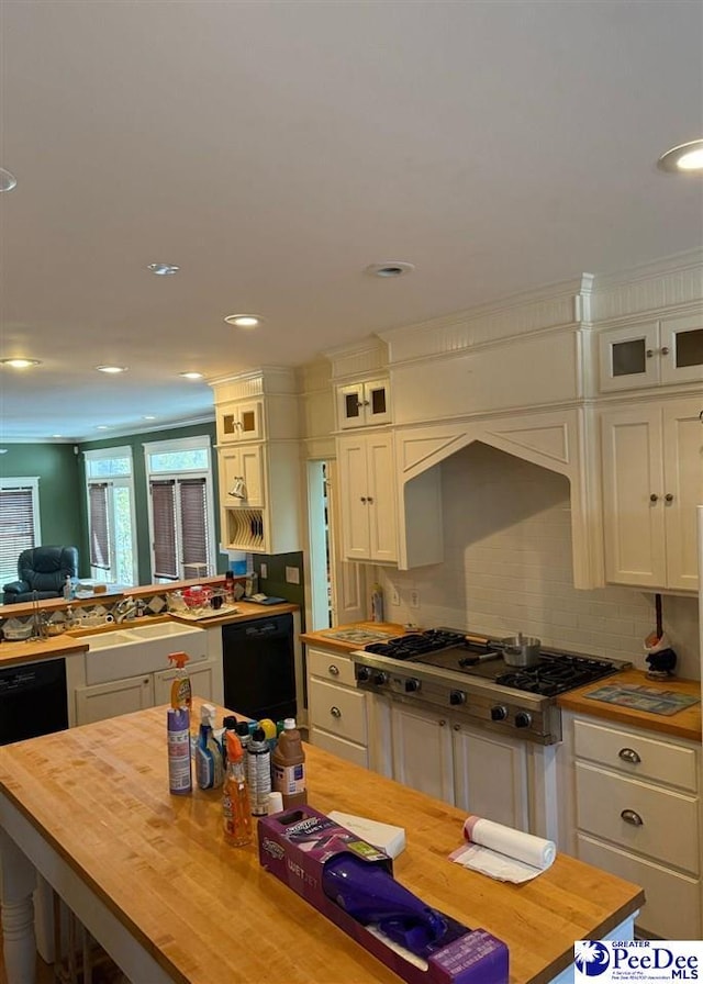 kitchen featuring glass insert cabinets, stainless steel gas stovetop, wood counters, and dishwasher