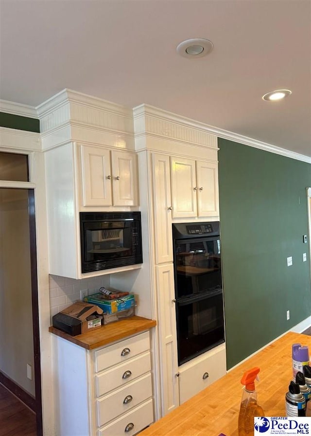 kitchen with crown molding, tasteful backsplash, butcher block counters, wood finished floors, and black appliances