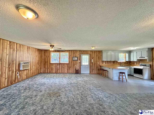 kitchen with open floor plan, electric range, and a breakfast bar area