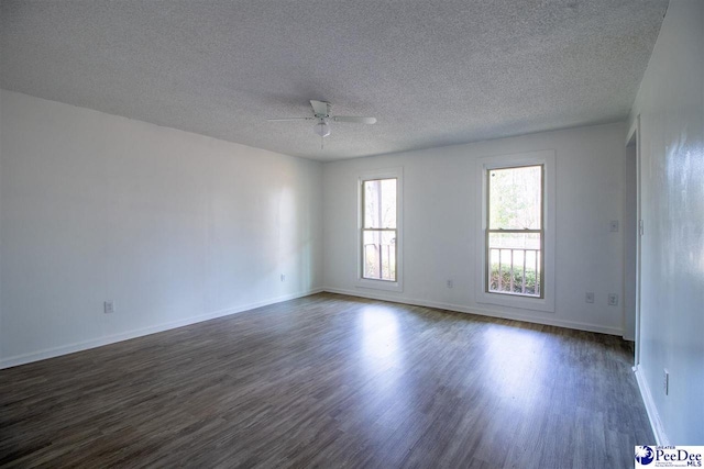 unfurnished room featuring ceiling fan, a textured ceiling, baseboards, and dark wood-style flooring