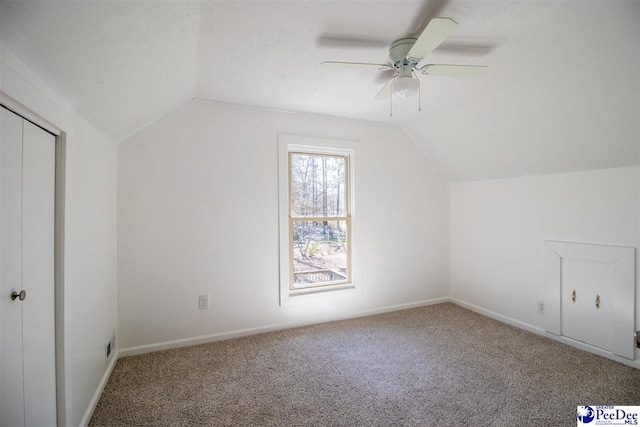 additional living space with lofted ceiling, carpet flooring, ceiling fan, and baseboards