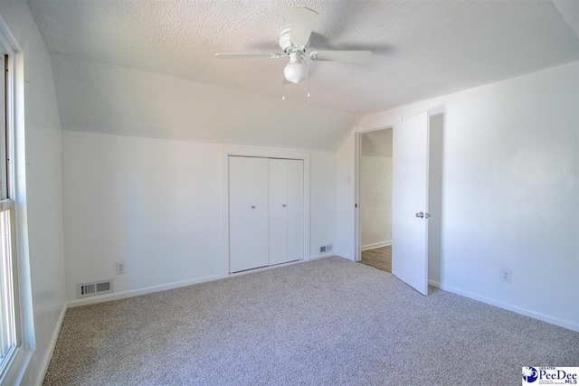 bonus room with visible vents, vaulted ceiling, a textured ceiling, and carpet flooring