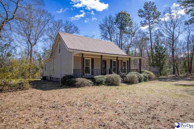 view of front of home with metal roof, a porch, and cooling unit