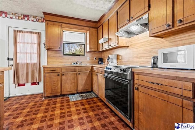 kitchen featuring brown cabinets, light countertops, white microwave, range with electric cooktop, and under cabinet range hood