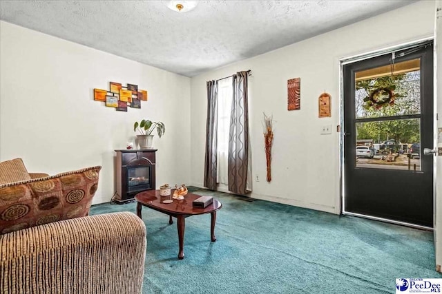 interior space featuring a glass covered fireplace, carpet flooring, and a textured ceiling