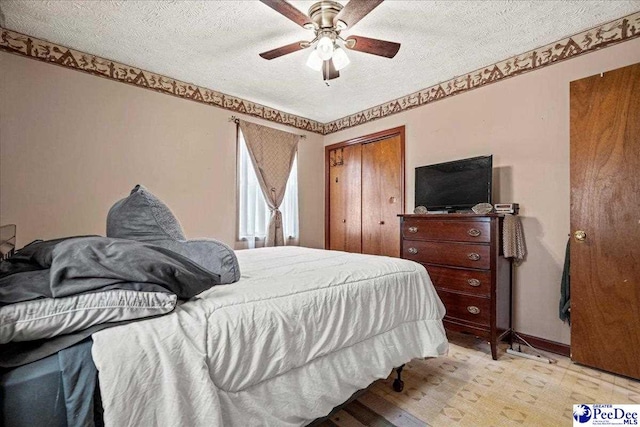 bedroom with baseboards, a closet, a ceiling fan, and a textured ceiling