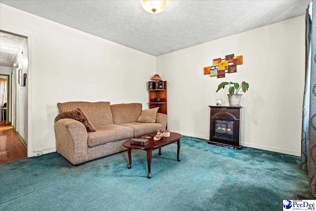 living room with carpet, a glass covered fireplace, a textured ceiling, and baseboards