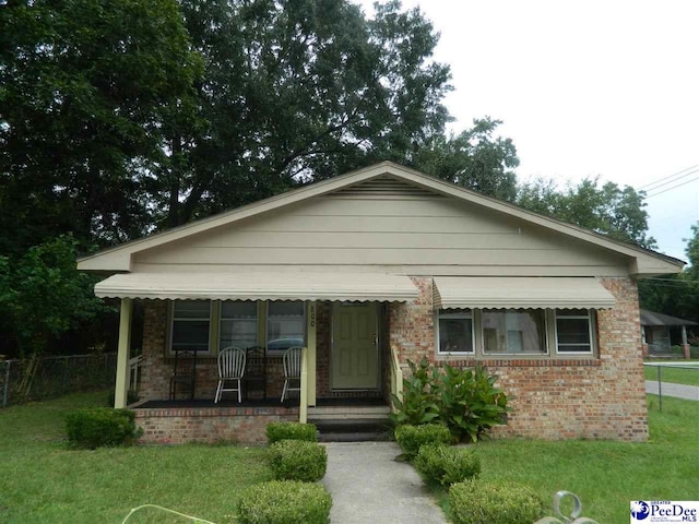 bungalow with a porch and a front lawn