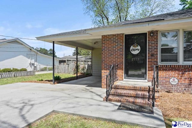 2111 W Cambridge Dr, Florence, SC 29501 - entrance to property featuring fence, driveway, brick siding, and a carport