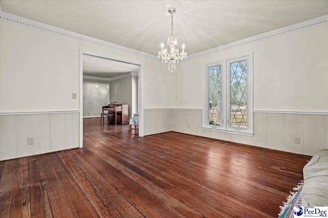 unfurnished dining area featuring a wainscoted wall, a chandelier, and hardwood / wood-style flooring