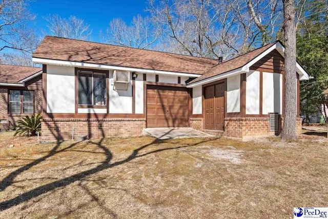 exterior space with brick siding, an attached garage, and a shingled roof