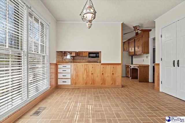 kitchen with black microwave, visible vents, crown molding, and brick patterned floor