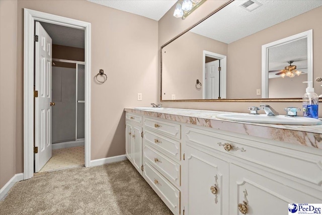 full bathroom featuring double vanity, a sink, visible vents, and a shower stall