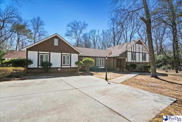 view of front of property featuring brick siding and driveway