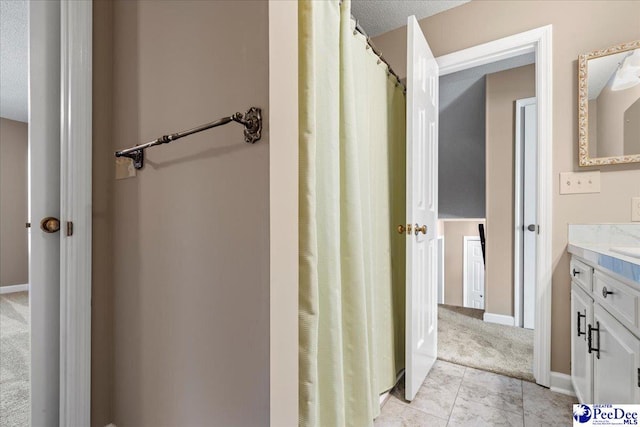 bathroom with tile patterned flooring, vanity, and baseboards