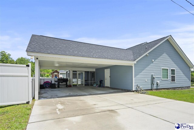 515 Young St, Darlington, SC 29532 - view of side of property with concrete driveway, a shingled roof, fence, and a carport