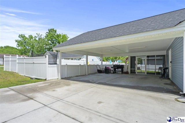 515 Young St, Darlington, SC 29532 - view of parking / parking lot featuring concrete driveway, fence, an attached carport, and a gate