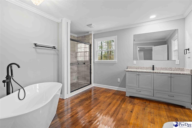 bathroom with a freestanding tub, crown molding, a shower stall, and hardwood / wood-style flooring