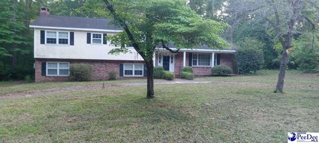 112 Williamson Pl, Darlington, SC 29532 - split level home featuring a chimney, a front yard, and brick siding