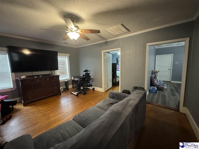 living room featuring visible vents, wood finished floors, ceiling fan, and ornamental molding