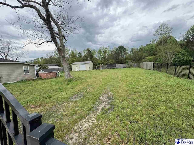view of yard featuring fence and an outdoor structure