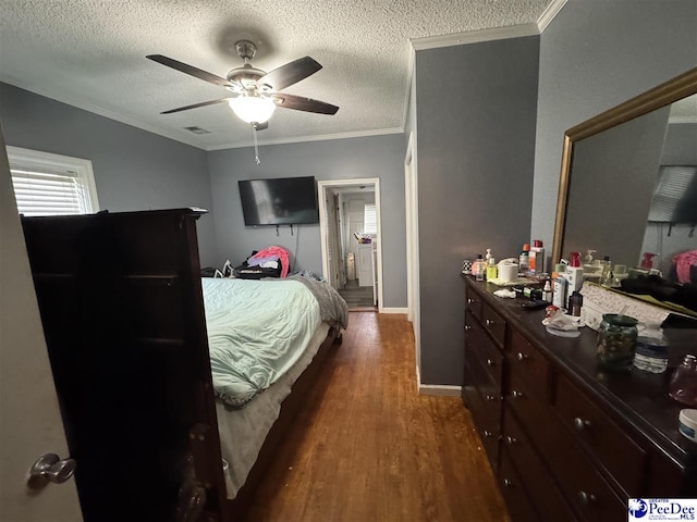 bedroom featuring a textured ceiling, visible vents, baseboards, ornamental molding, and dark wood finished floors