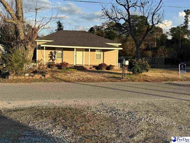 view of front of house featuring fence and a porch